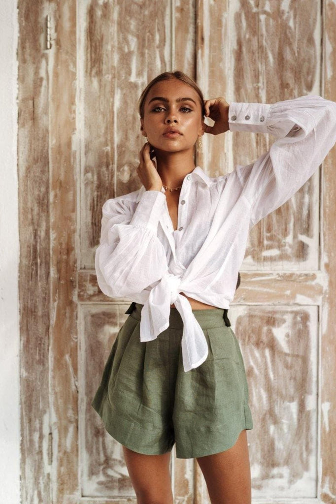 woman in a white shirt made of linen and green stylish shorts